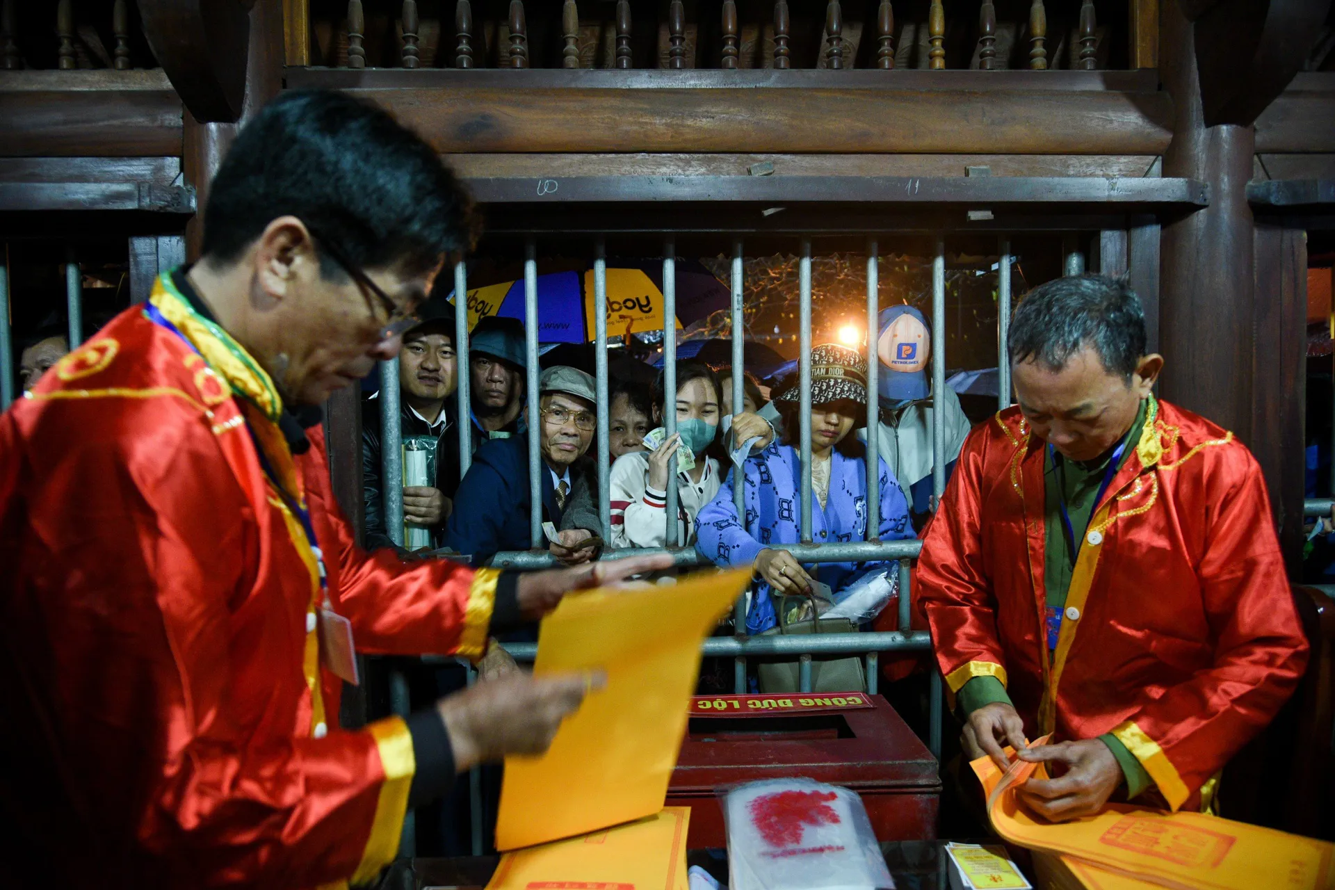 Người dân cầm sẵn tiền lẻ, ngủ gật trong lúc xếp hàng chờ lấy ấn đền Trần