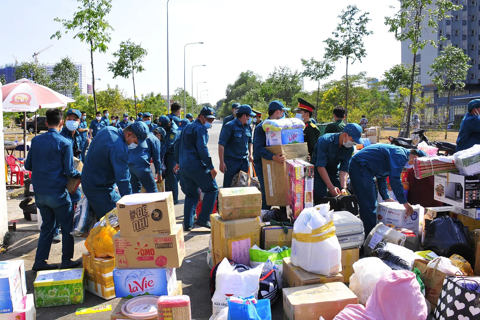 Dân quân “căng mình” dưới nắng nhận đồ tiếp tế người phải cách ly phòng dịch Covid-19