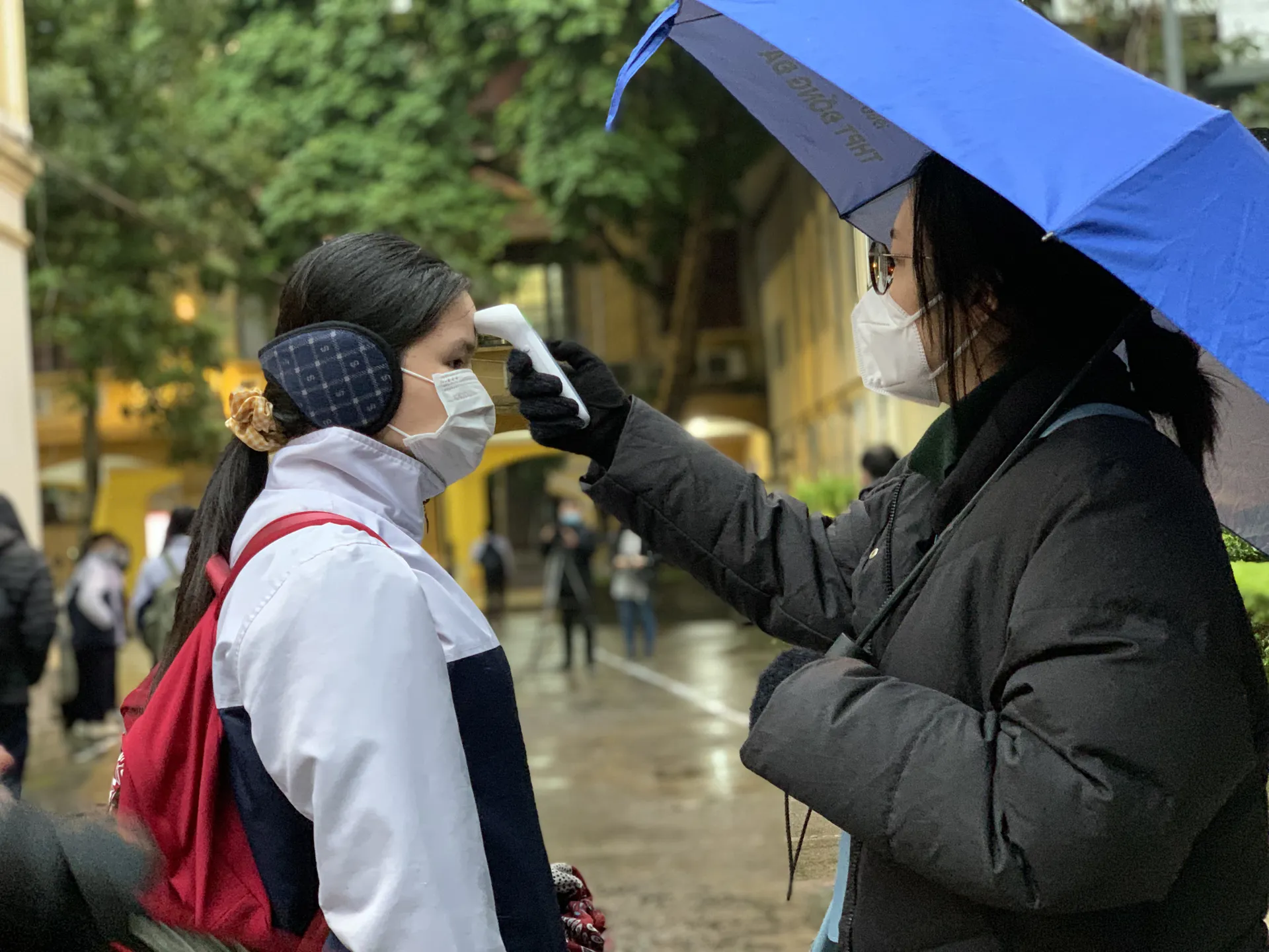 Hơn chục cán bộ, giáo viên trường THPT Phan Đình Phùng đứng ở nhiều vị trí đo thân nhiệt cho học sinh
