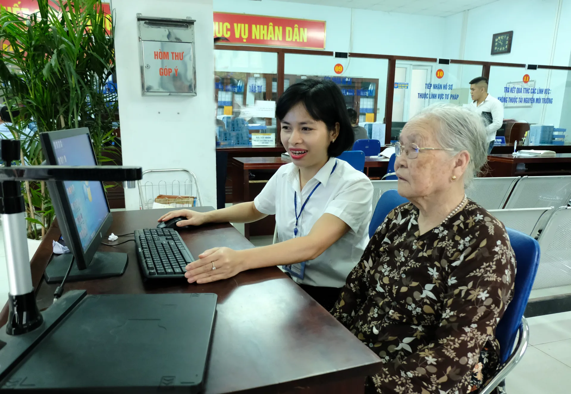 Cán bộ UBND quận Bắc Từ Liêm hướng dẫn người cao tuổi làm thủ tục hành chính. Ảnh: Công Hung