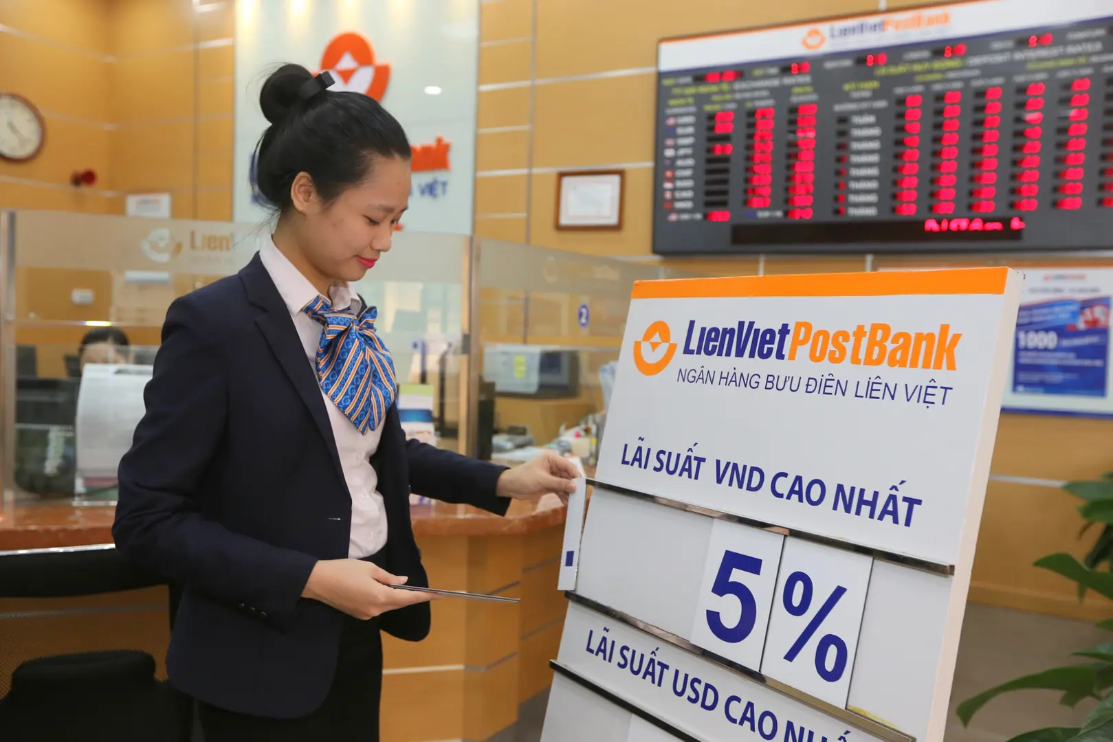 Nhân viên LienVietPostBank điểu chỉnh bảng lãi suất. Ảnh: Phạm Hùng