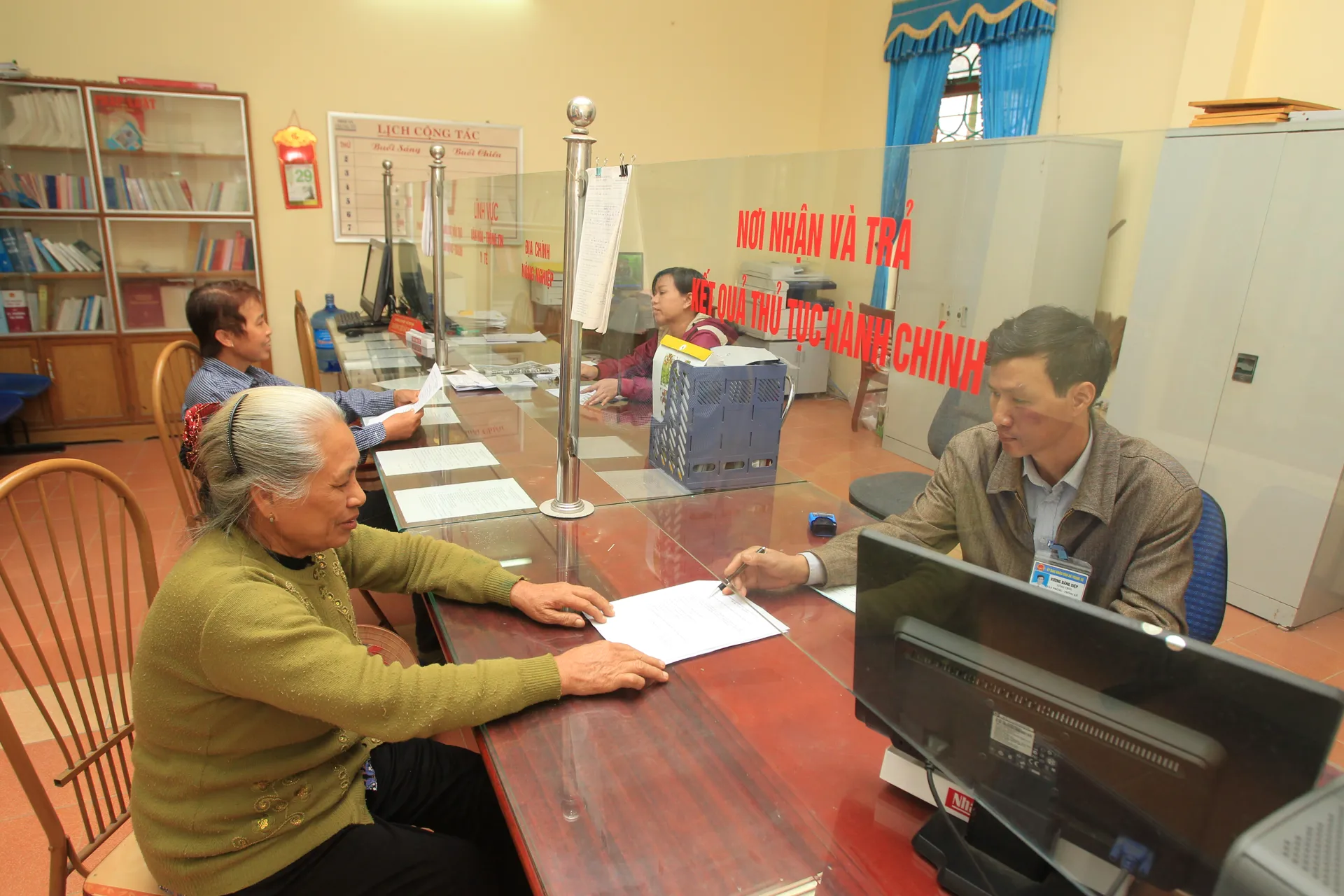 Hướng dẫn người dân làm thủ tục hành chính tại xã Trung Tú, huyện Ứng Hòa. Ảnh: Công Hùng
