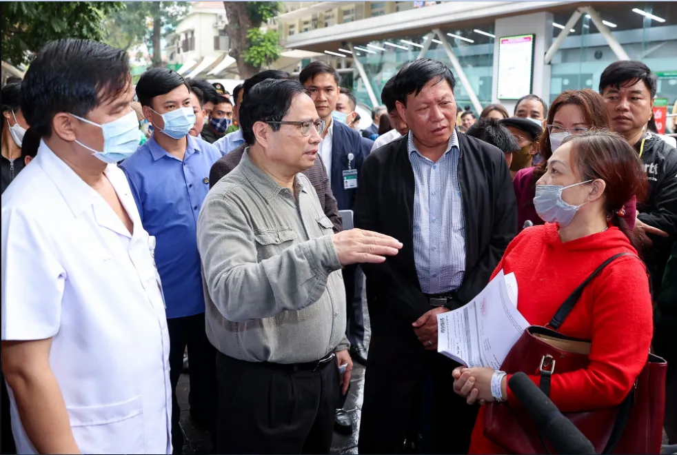 Thủ tướng thăm hỏi người nhà bệnh nhân về tình hình đáp ứng vật tư y tế và thuốc men tại bệnh viện Bạch Mai. Ảnh: Nhật Bắc