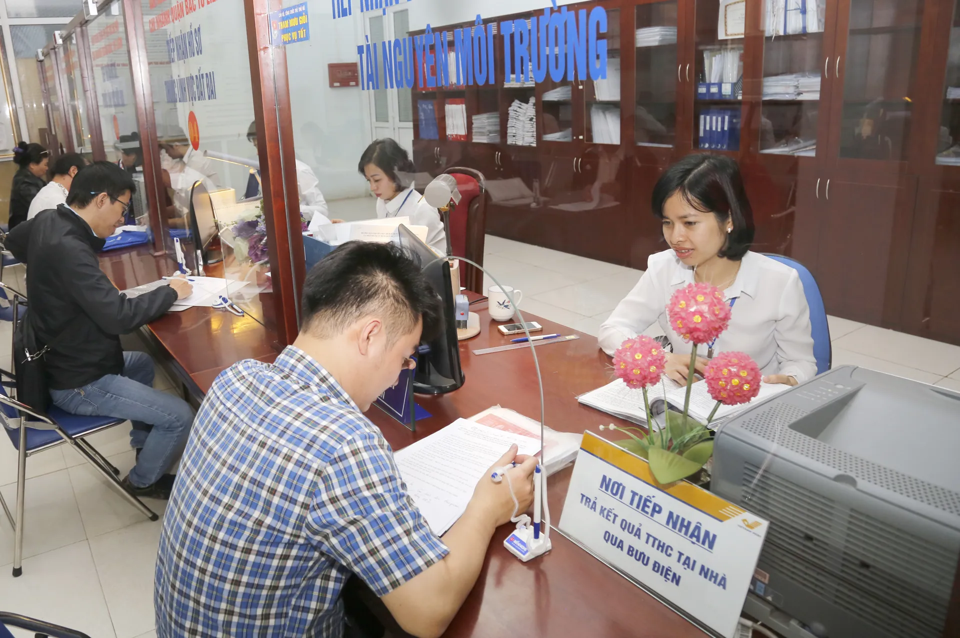 Hướng dẫn người dân làm thủ tục hành chính tại bộ phận một cửa quận Bắc Từ Liêm. Ảnh: Hải Linh