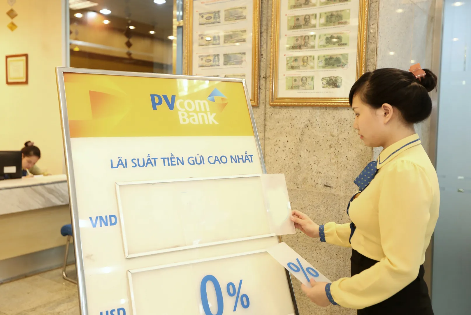 Nhân viên PVBank hiệu chỉnh bảng lãi suất. Ảnh: Phạm Hùng