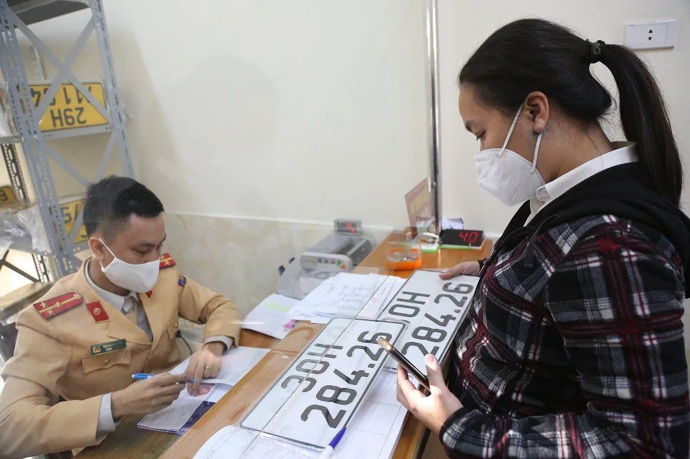Người dân đăng ký biển số xe tại cơ sở đăng ký xe ô tô số 2, đường Láng. Ảnh: Phạm Công
