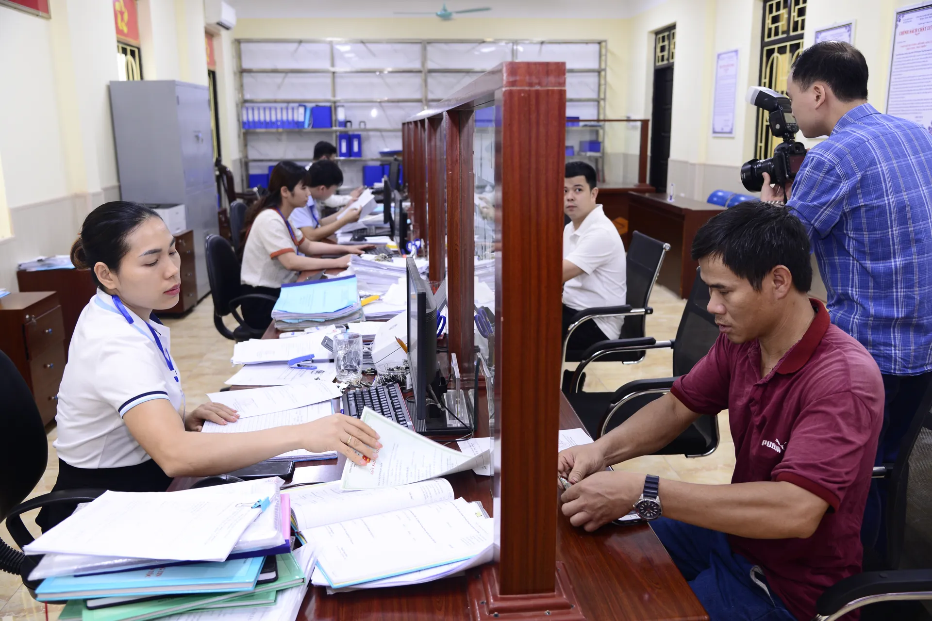 Cán bộ UBND huyện Ứng Hòa hướng dẫn người dân làm thủ tục hành chính. Ảnh: Phạm Hùng