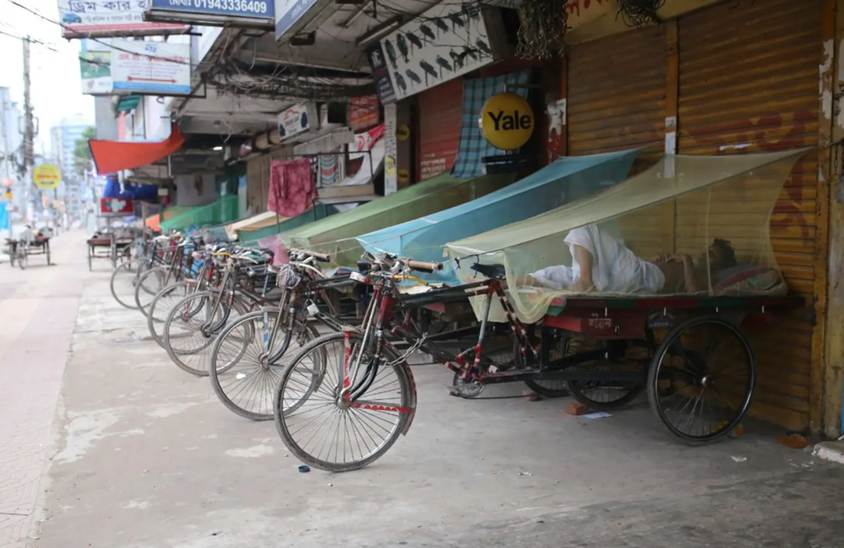 Người vô gia cư ngủ trên xe trang bị màn chống muỗi ở thủ đô Dhaka, Bangladesh. Ảnh New York Post