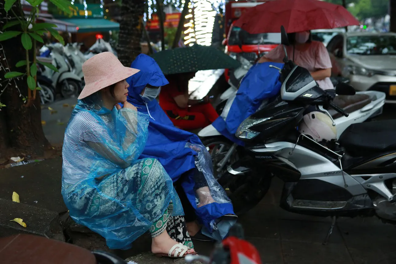 Gần 1 tiếng trôi qua, mưa ngày càng nặng hạt nhưng nhiều phụ huynh tại điểm thi Trường THCS Yên Hòa - Cầu Giấy vẫn kiên nhẫn đợi con. (Ảnh: Ngọc Tú)