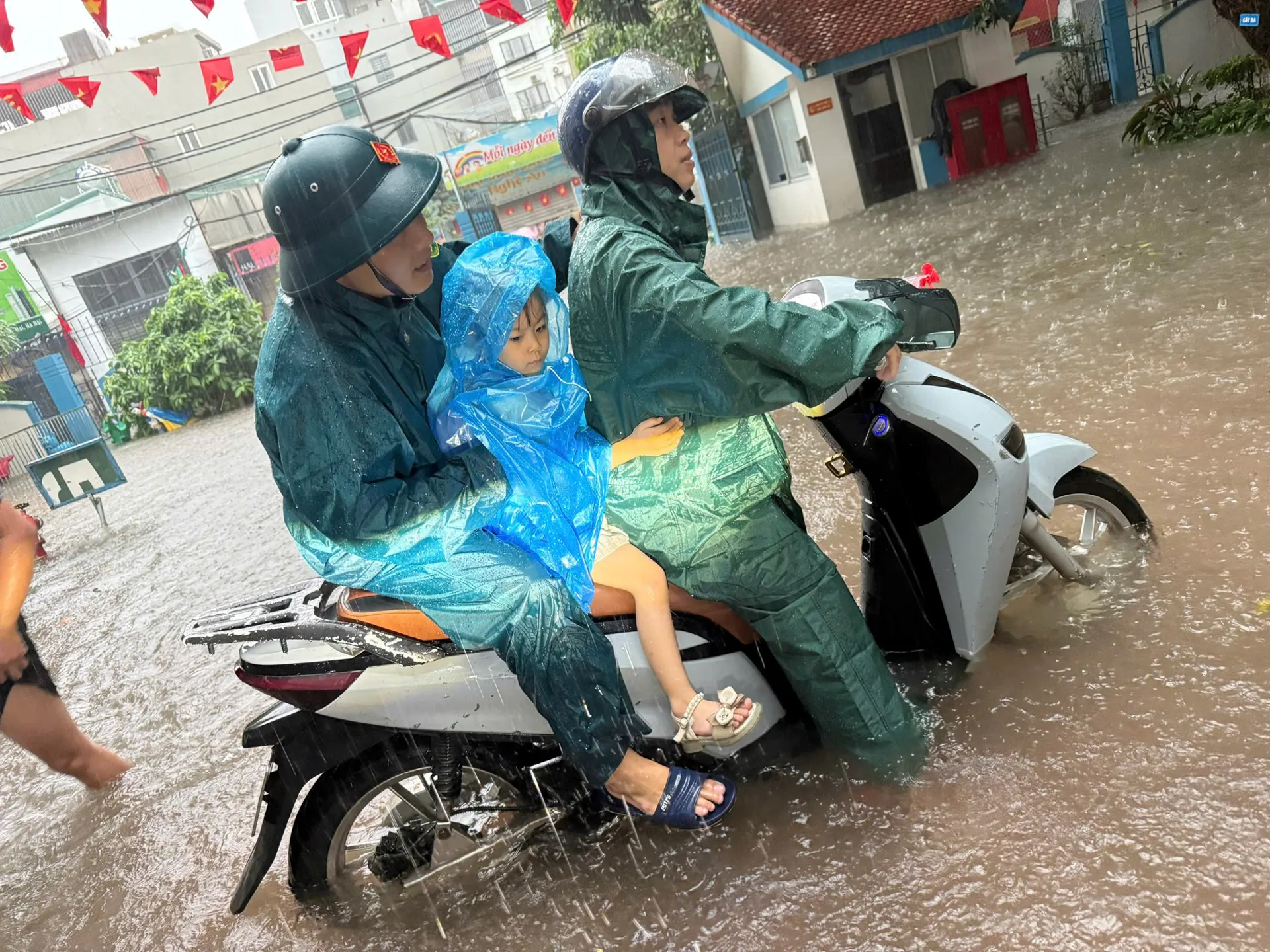 Dân quân tự vệ phường Định Công đưa hàng chục học sinh về nhà trong mưa lớn